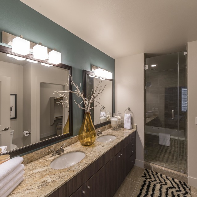 The Arcadian - Bathroom Featuring Double Sinks, Mirrors, a Stylish Vase, and a Glass Shower