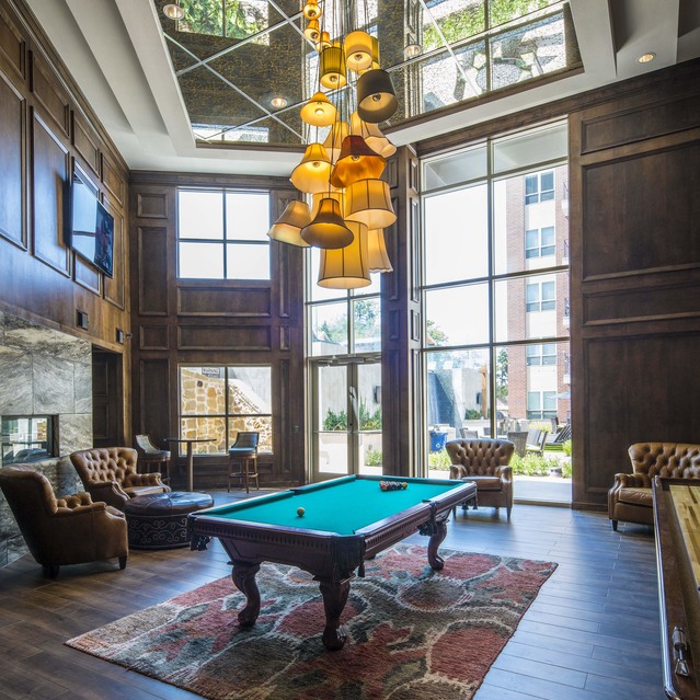 The Arcadian - Stylish Lounge Featuring a Pool Table, Elegant Chairs, and a Striking Chandelier Above