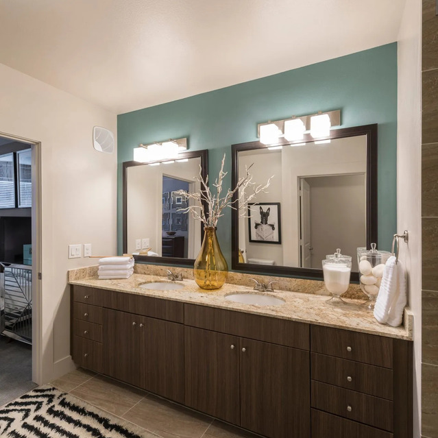 The Arcadian - Bathroom Featuring a Double Vanity with Wood Cabinetry, Marble Countertop, and a Turquoise Accent Wall