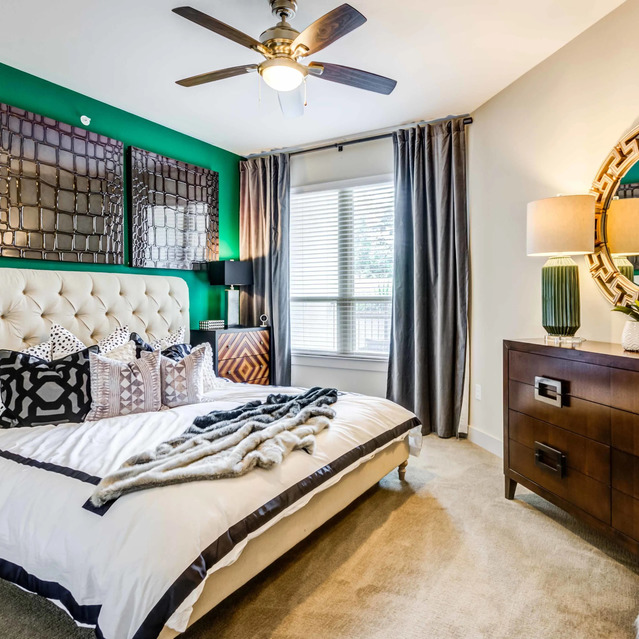 The Arcadian - Bedroom with a Plush White Bed, Geometric Pillows, and a Green Accent Wall