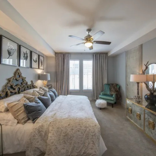 The Arcadian - Luxurious Bedroom with Ornate Headboard, Elegant Decor, and a Ceiling Fan