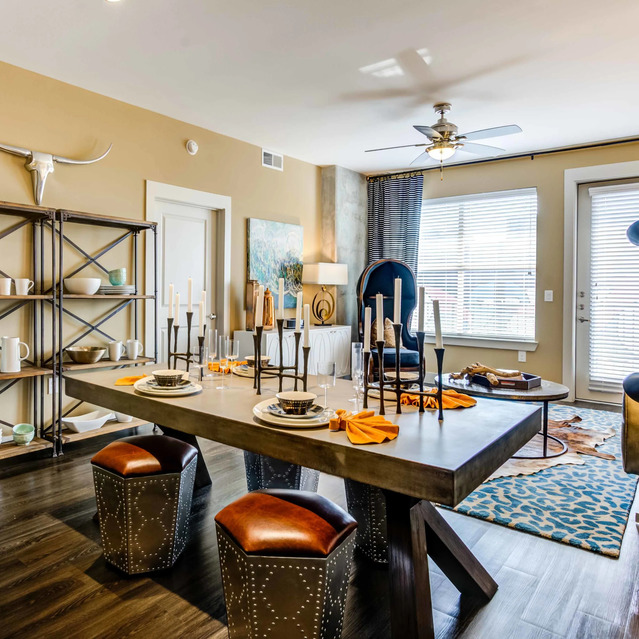 The Arcadian - Modern Dining-Living Area with a Rustic Wood Table, Leather Stools, and Metal Shelves