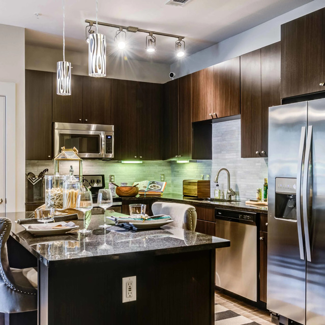 The Arcadian - Modern Kitchen with Dark Wood Cabinets, Stainless Steel Appliances, and a Marble Island
